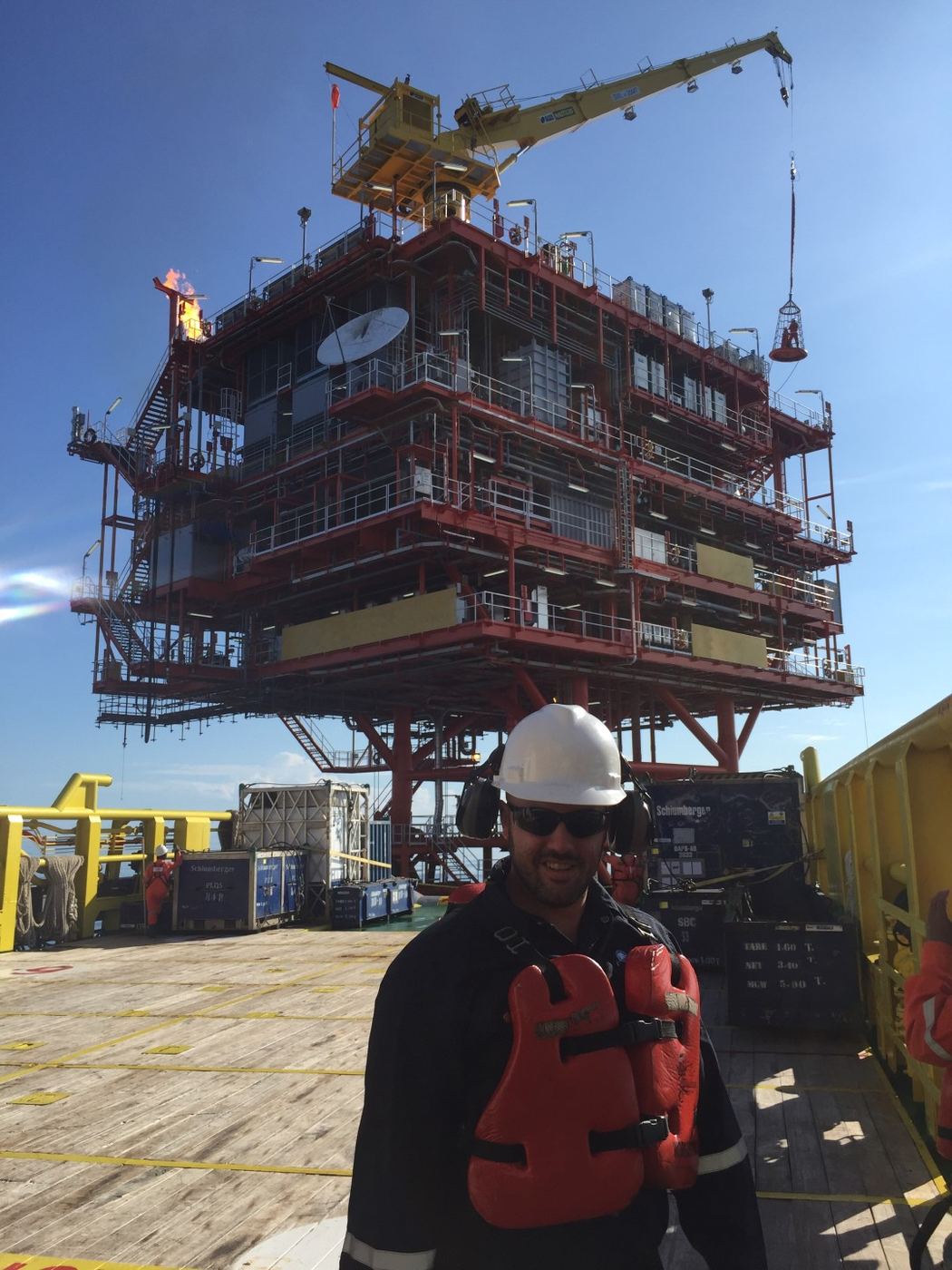 Jose Campins on an offshore platform deck in PPE, with topsides equipment behind